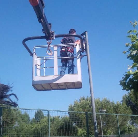 : Electricista realizando el mantenimiento del alumbrado exterior de una comunidad de vecinos en Majadahonda
